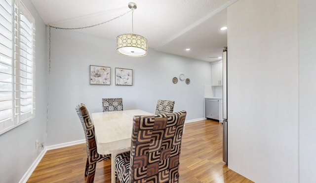 dining space with ceiling fan and light wood-type flooring