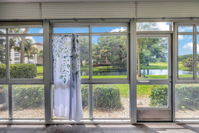 interior space featuring a water view and carpet