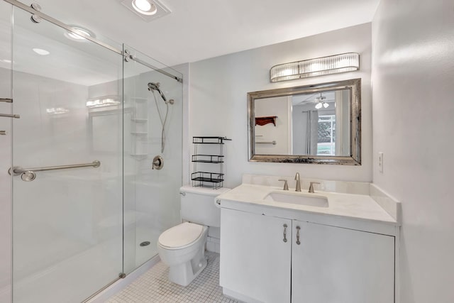 bathroom with an enclosed shower, toilet, vanity, ceiling fan, and tile patterned floors