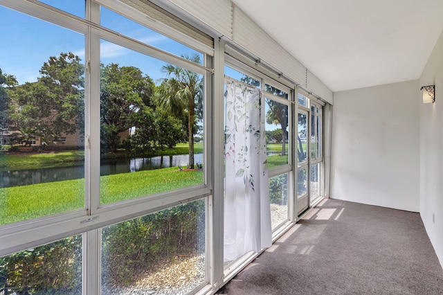 unfurnished sunroom featuring a water view