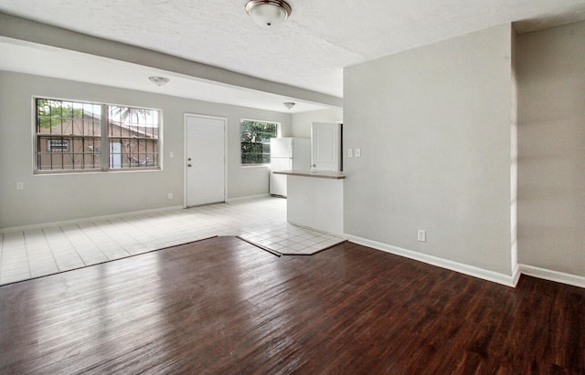 unfurnished living room featuring light tile patterned flooring and a textured ceiling