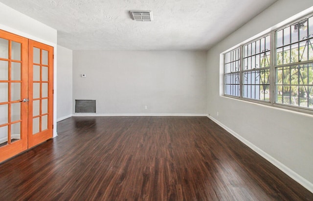 empty room with hardwood / wood-style flooring, french doors, and a textured ceiling