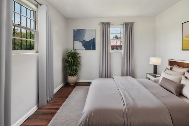 bedroom featuring dark wood-type flooring and multiple windows