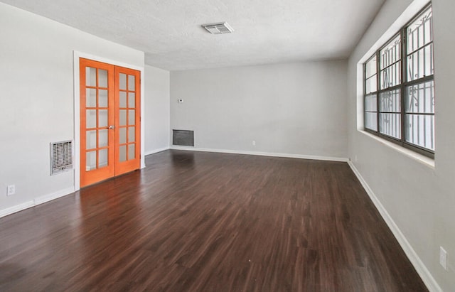 unfurnished room with french doors, hardwood / wood-style flooring, and a textured ceiling