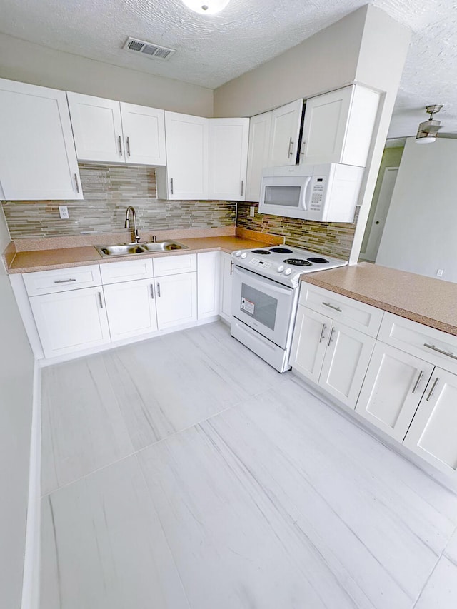 kitchen with sink, white cabinetry, backsplash, and white appliances