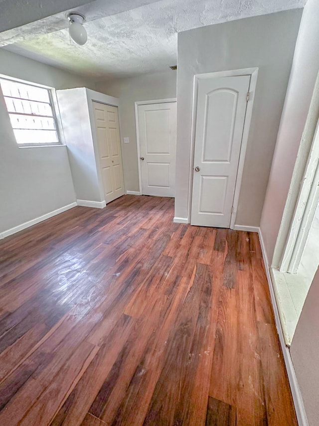 unfurnished bedroom featuring a textured ceiling and hardwood / wood-style flooring