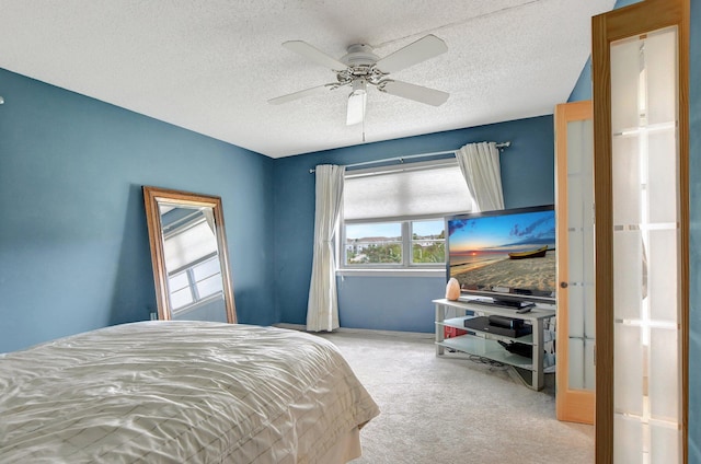 carpeted bedroom with ceiling fan and a textured ceiling