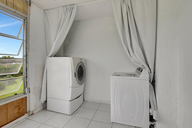 laundry room with independent washer and dryer and light tile patterned flooring