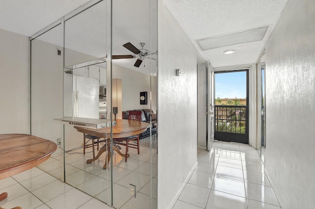 tiled dining area featuring ceiling fan and a textured ceiling