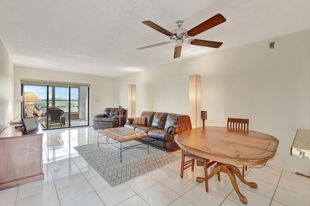 living room featuring light tile patterned flooring, a textured ceiling, and ceiling fan