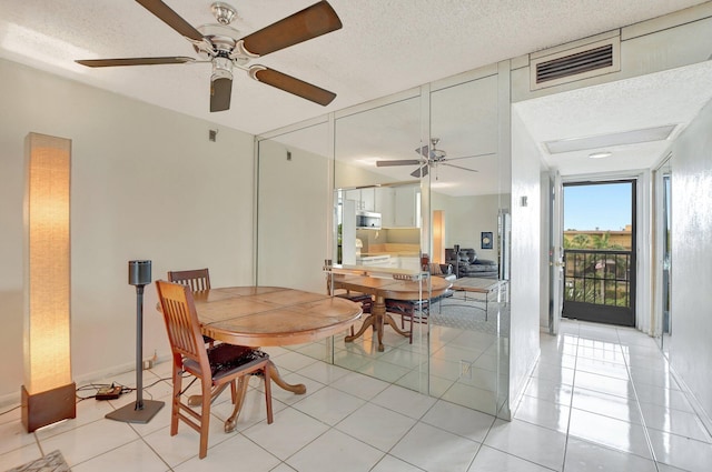 dining room featuring ceiling fan, a textured ceiling, and light tile patterned floors