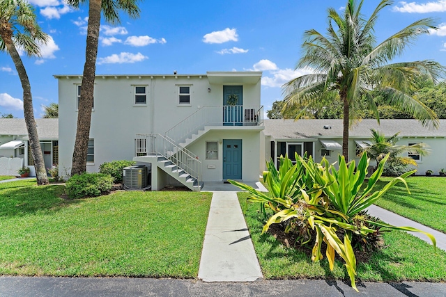 view of front of property featuring cooling unit and a front lawn