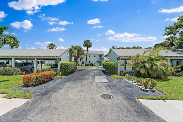 view of front of property with a carport and a front lawn