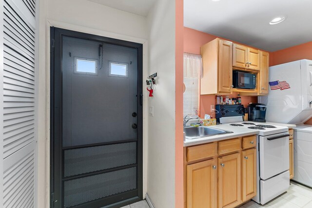 kitchen featuring black microwave, sink, light brown cabinets, white range with electric stovetop, and light tile patterned floors