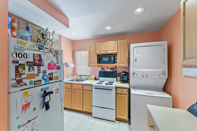 kitchen featuring light brown cabinetry, stacked washing maching and dryer, white appliances, sink, and light tile patterned floors