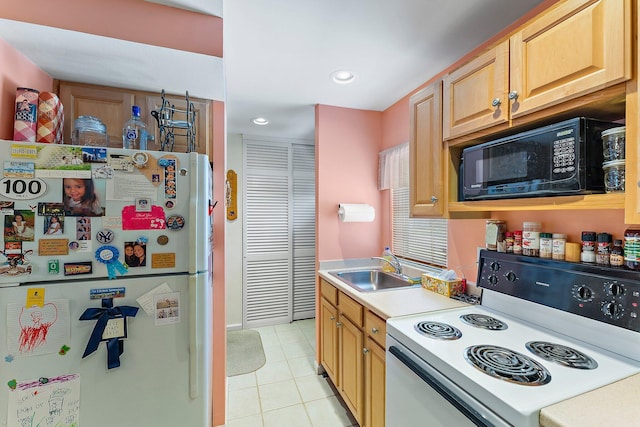 kitchen with sink, white fridge, light tile patterned floors, and stove