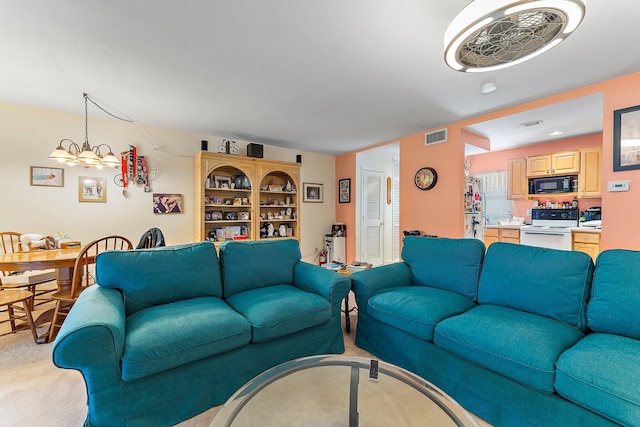 living room with a notable chandelier and light colored carpet