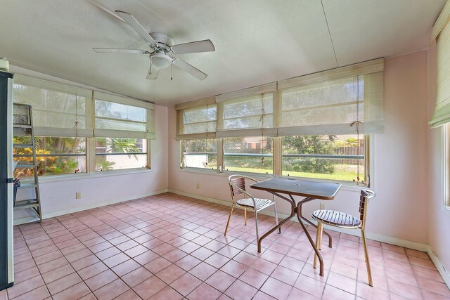 unfurnished sunroom with ceiling fan