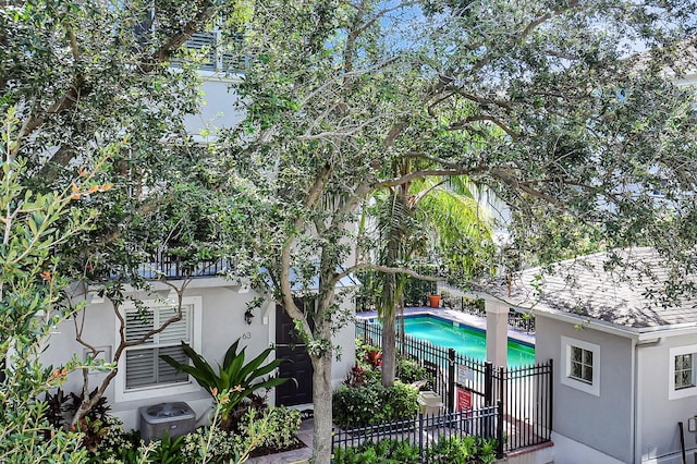 view of property featuring central AC and a fenced in pool