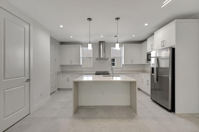 kitchen with light tile patterned flooring, wall chimney range hood, a kitchen island, appliances with stainless steel finishes, and sink