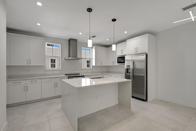 kitchen featuring light tile patterned flooring, appliances with stainless steel finishes, sink, and wall chimney range hood