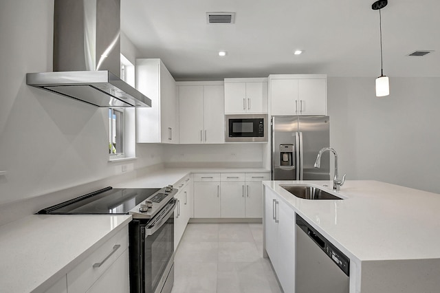 kitchen featuring stainless steel appliances, pendant lighting, wall chimney exhaust hood, sink, and light tile patterned floors