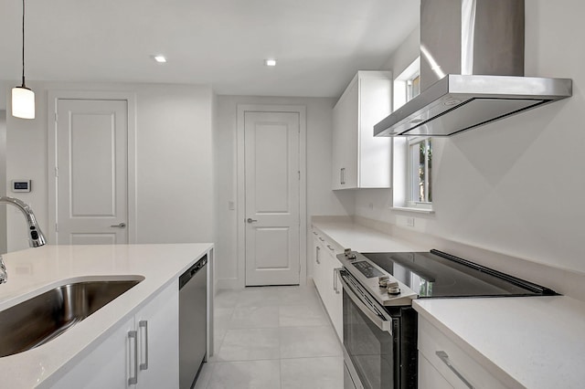 kitchen with white cabinets, stainless steel appliances, light tile patterned flooring, and wall chimney exhaust hood