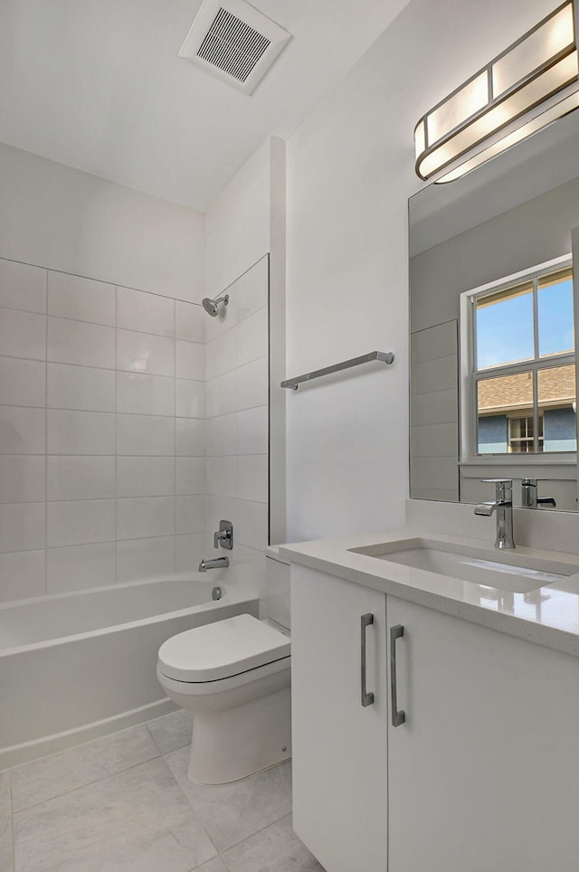 full bathroom with tiled shower / bath combo, tile patterned floors, toilet, and vanity