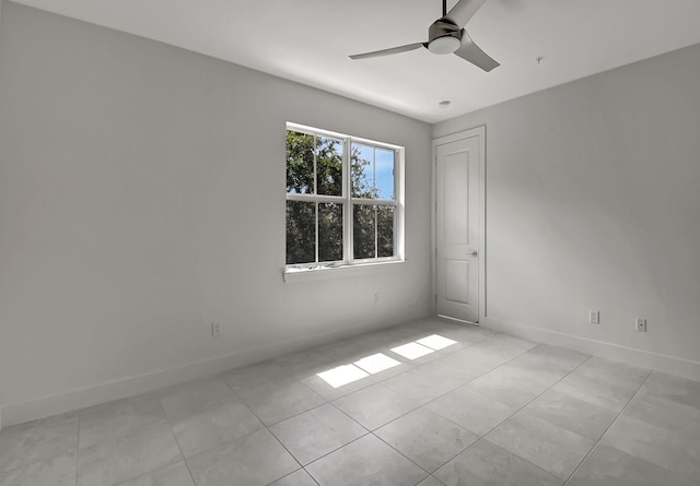 tiled empty room featuring ceiling fan