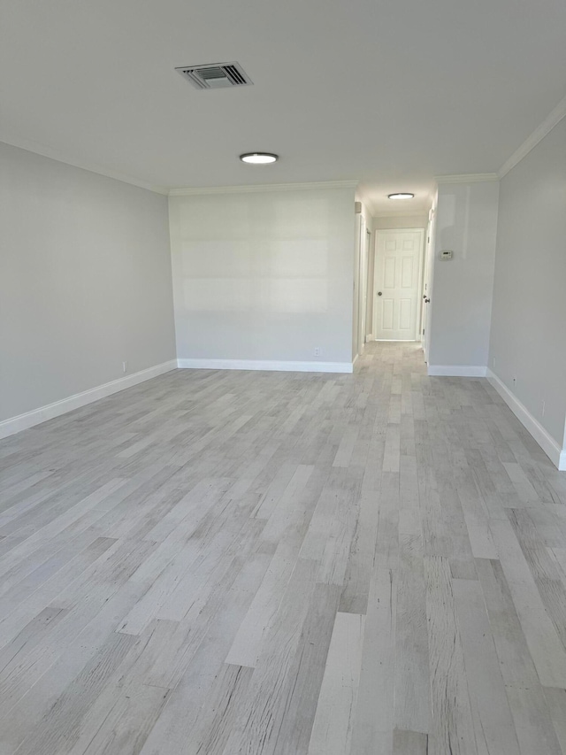 unfurnished room with light wood-type flooring and crown molding