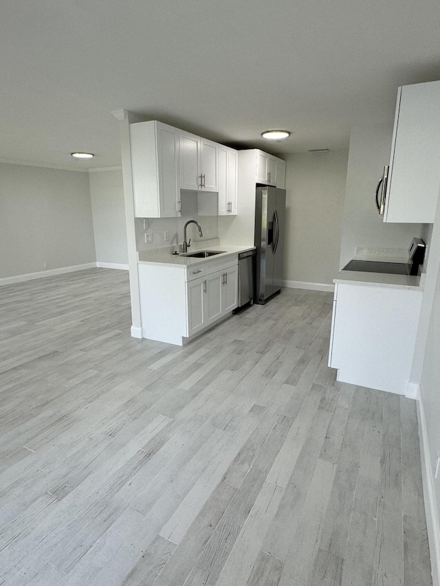 kitchen with white cabinetry, sink, stainless steel appliances, and light wood-type flooring