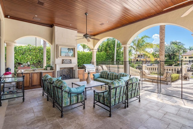 view of patio / terrace with ceiling fan, grilling area, an outdoor hangout area, and an outdoor kitchen