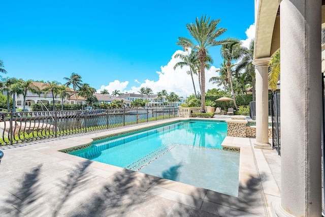 view of pool with a water view and a patio area