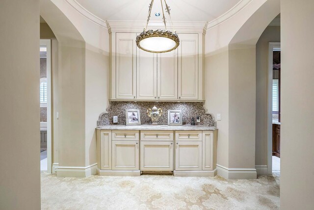 bar featuring ornamental molding, light carpet, cream cabinetry, and tasteful backsplash