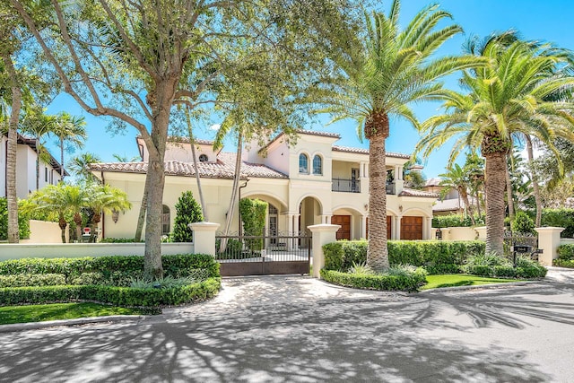 mediterranean / spanish-style house featuring a garage and a balcony