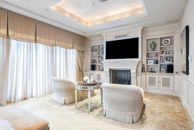 living area featuring built in shelves, a tray ceiling, and a wealth of natural light