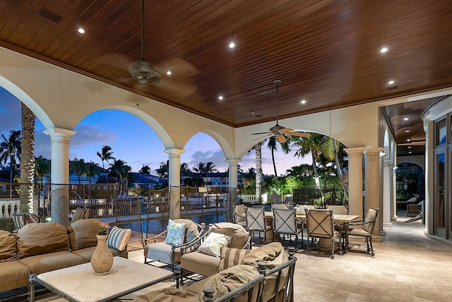 patio terrace at dusk featuring an outdoor living space and ceiling fan