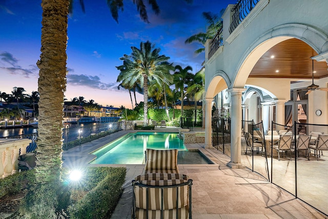 pool at dusk with a patio