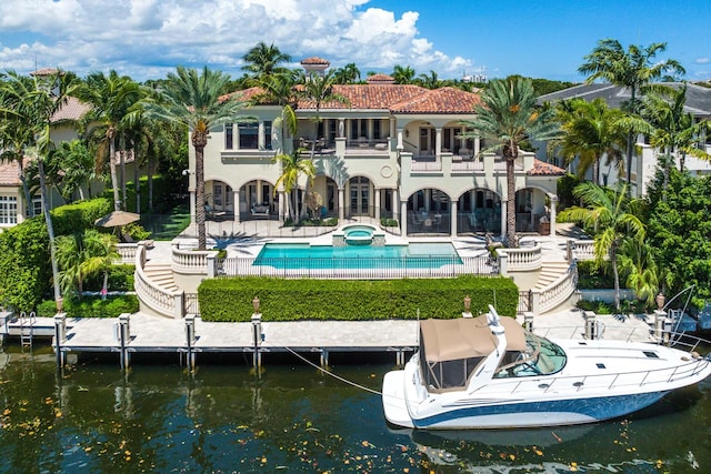 back of house featuring a water view, a patio, and a balcony