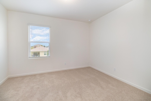 carpeted spare room with baseboards