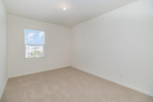 carpeted spare room featuring baseboards