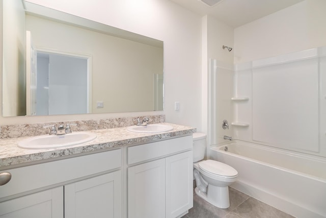 full bathroom featuring toilet, tile patterned floors, double vanity, and a sink