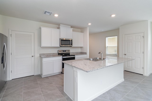 kitchen featuring visible vents, white cabinets, a sink, a kitchen island with sink, and stainless steel appliances