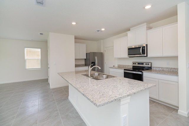 kitchen featuring white cabinetry, light tile patterned floors, an island with sink, stainless steel appliances, and sink