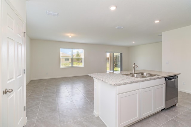 kitchen featuring open floor plan, light tile patterned floors, a center island with sink, stainless steel dishwasher, and a sink