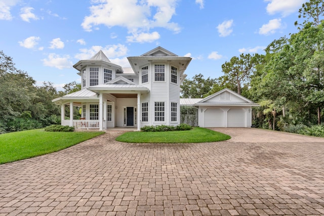 view of front facade featuring a garage, covered porch, an outdoor structure, and a front lawn