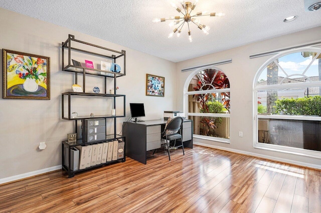 office featuring an inviting chandelier, a textured ceiling, and light hardwood / wood-style floors