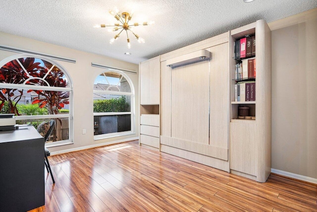 interior space featuring hardwood / wood-style floors, a textured ceiling, and a chandelier