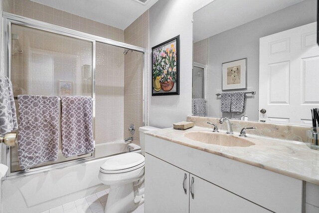 full bathroom featuring enclosed tub / shower combo, vanity, toilet, and tile patterned floors