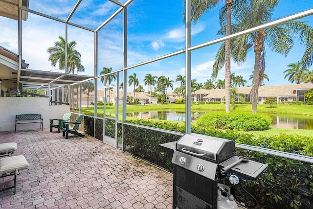 view of patio / terrace featuring a water view, area for grilling, and a lanai